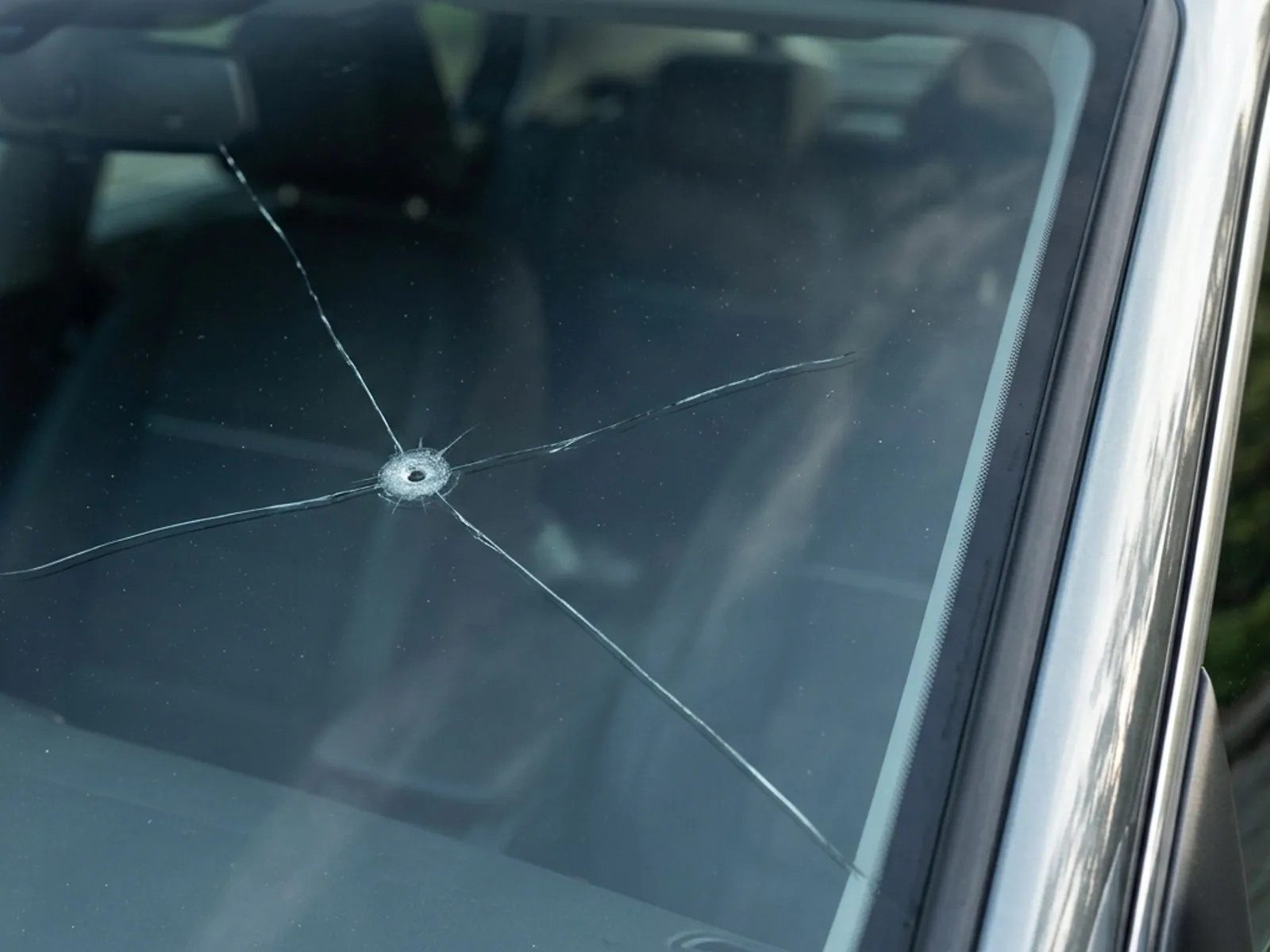 A combination break: a small circular chip with irregular cracks running away from it.
