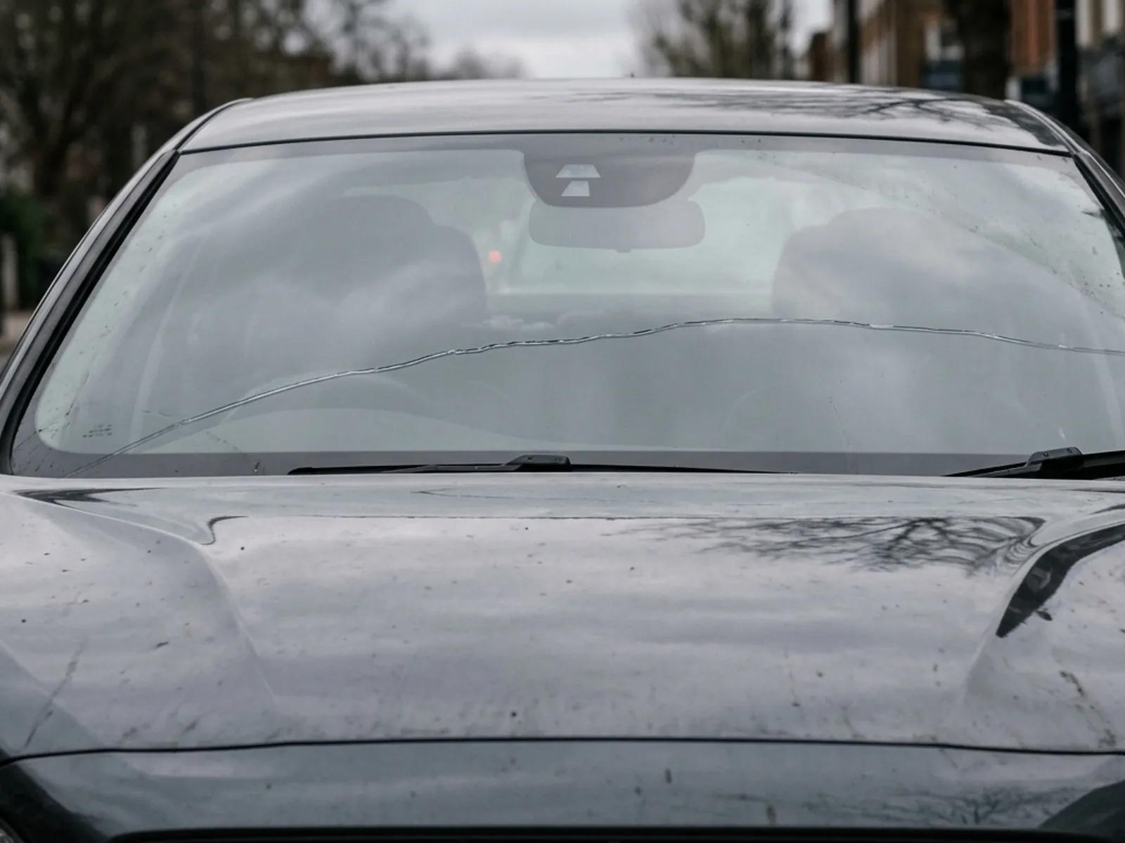 A long crack running across most of the width of a windshield.