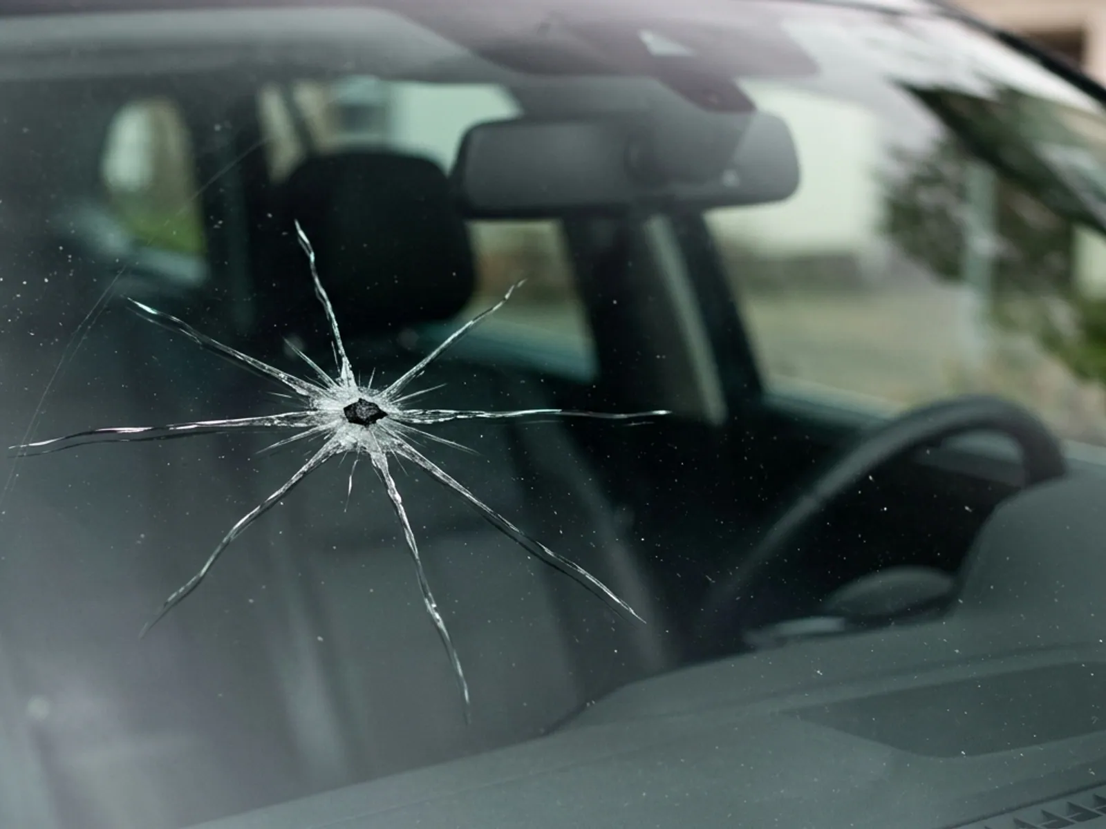 A star break in a windshield, thin cracks radiating outward from a central impact point.
