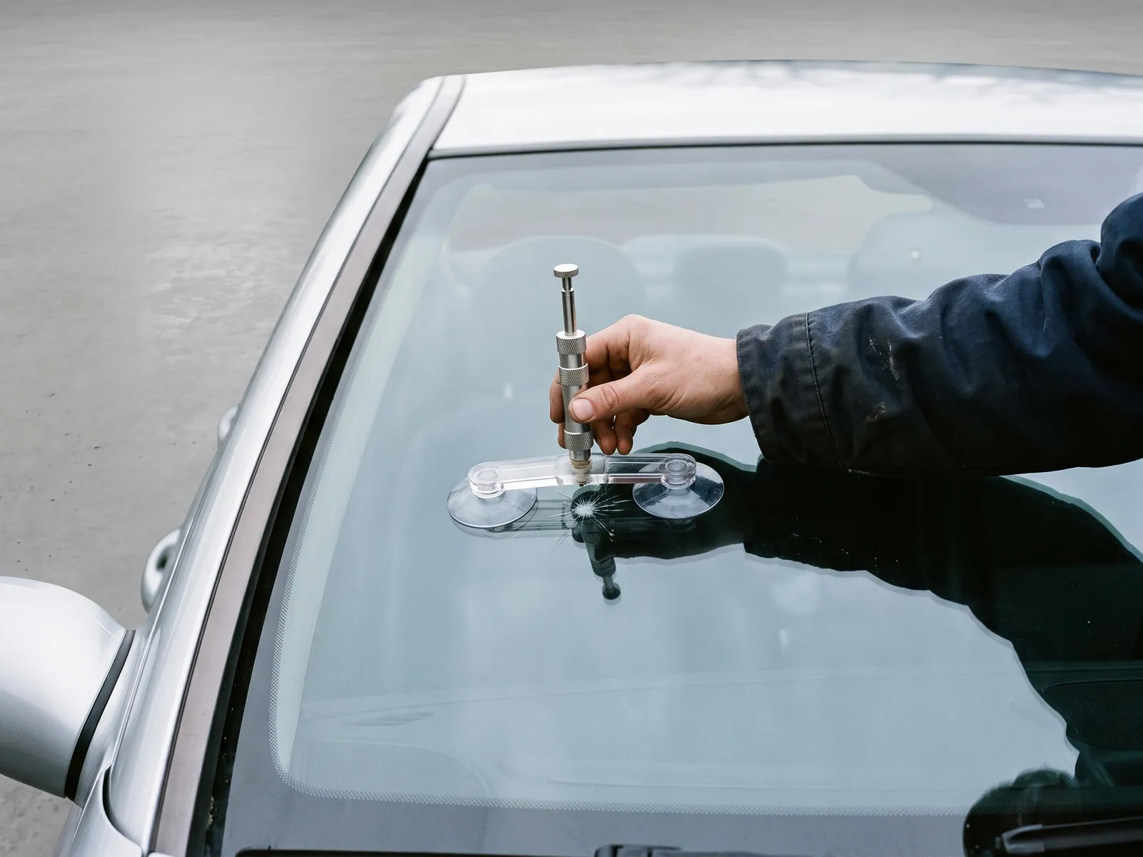 A Glass Genie technician carrying out windshield repair on a vehicle.